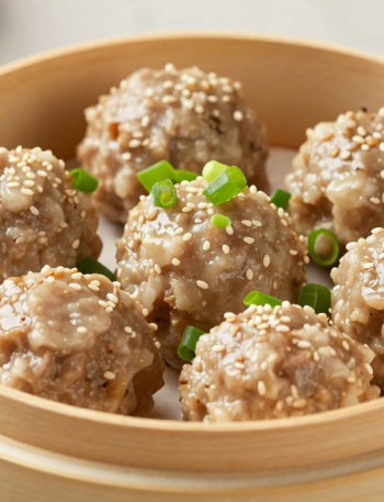 Steamed keto pork and shrimp dim sum meatballs in a bamboo steamer