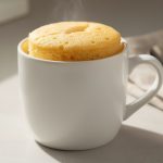 Keto vanilla mug cake in a white mug with a fluffy, soft top.